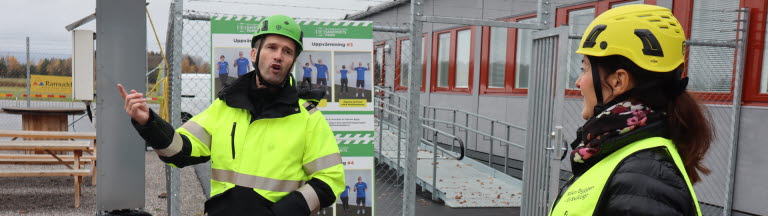 Kvinna på studiebesök i Byggbranschens Säkerhetspark lyssnar till introduktion av studiebesöket.