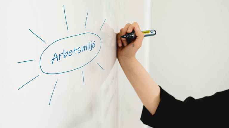 Hand skriver på whiteboard