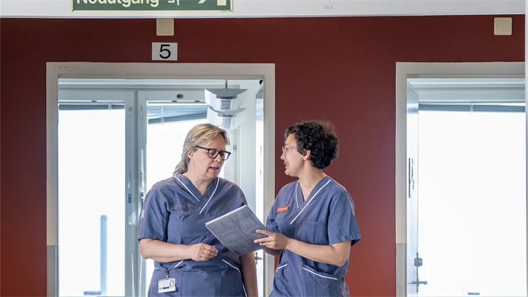 Två sjuksköterskor pratar i korridoren.