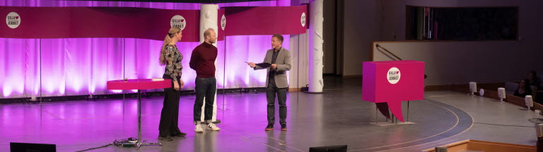 Två män och en kvinna på en stor scen inleder arbetsmiljöeventet Gilla Jobbet 2022 i Folkets hus i Stockholm.