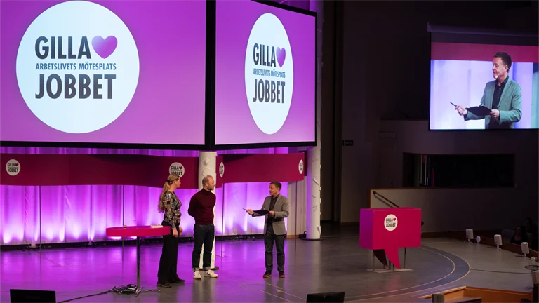 tre personer på en stor scen på eventet gilla jobbet