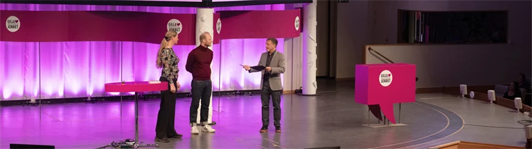 Två män och en kvinna på en stor scen inleder arbetsmiljöeventet Gilla Jobbet 2022 i Folkets hus i Stockholm.