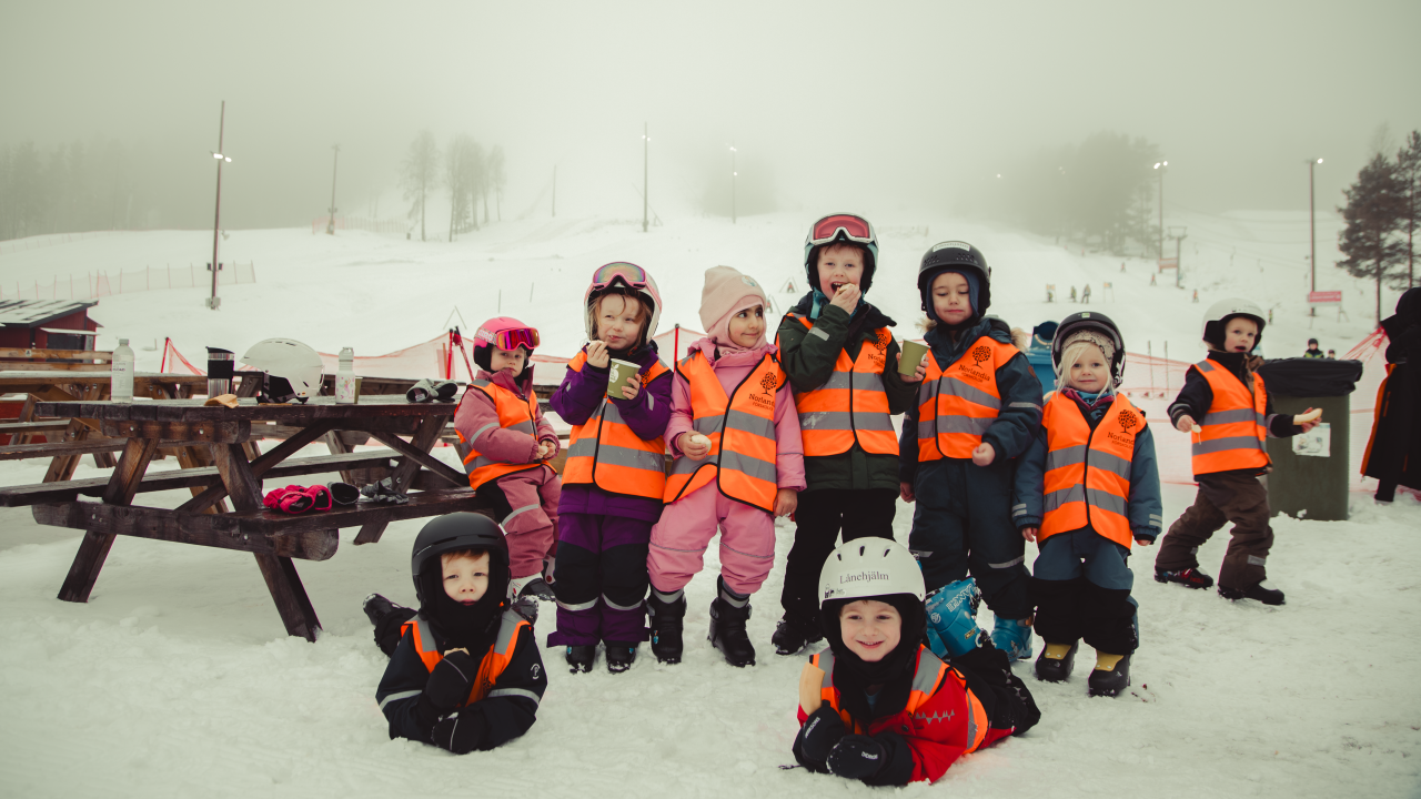 Förskolebarn med reflexvästar i ett vinterlandskap.